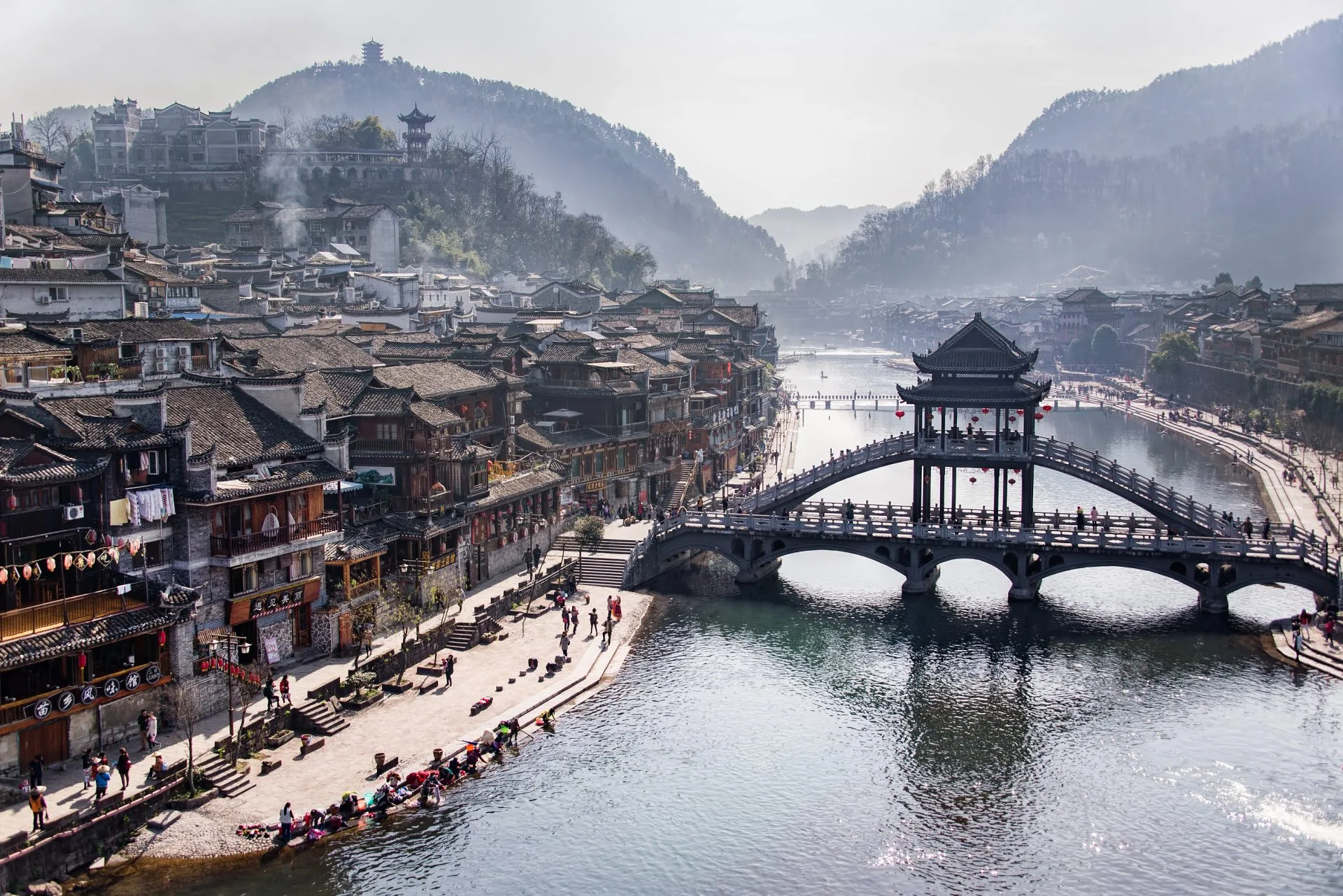 Pueblo de Fenghuang iluminado de noche junto al río Tuojiang, China, durante un viaje en familia