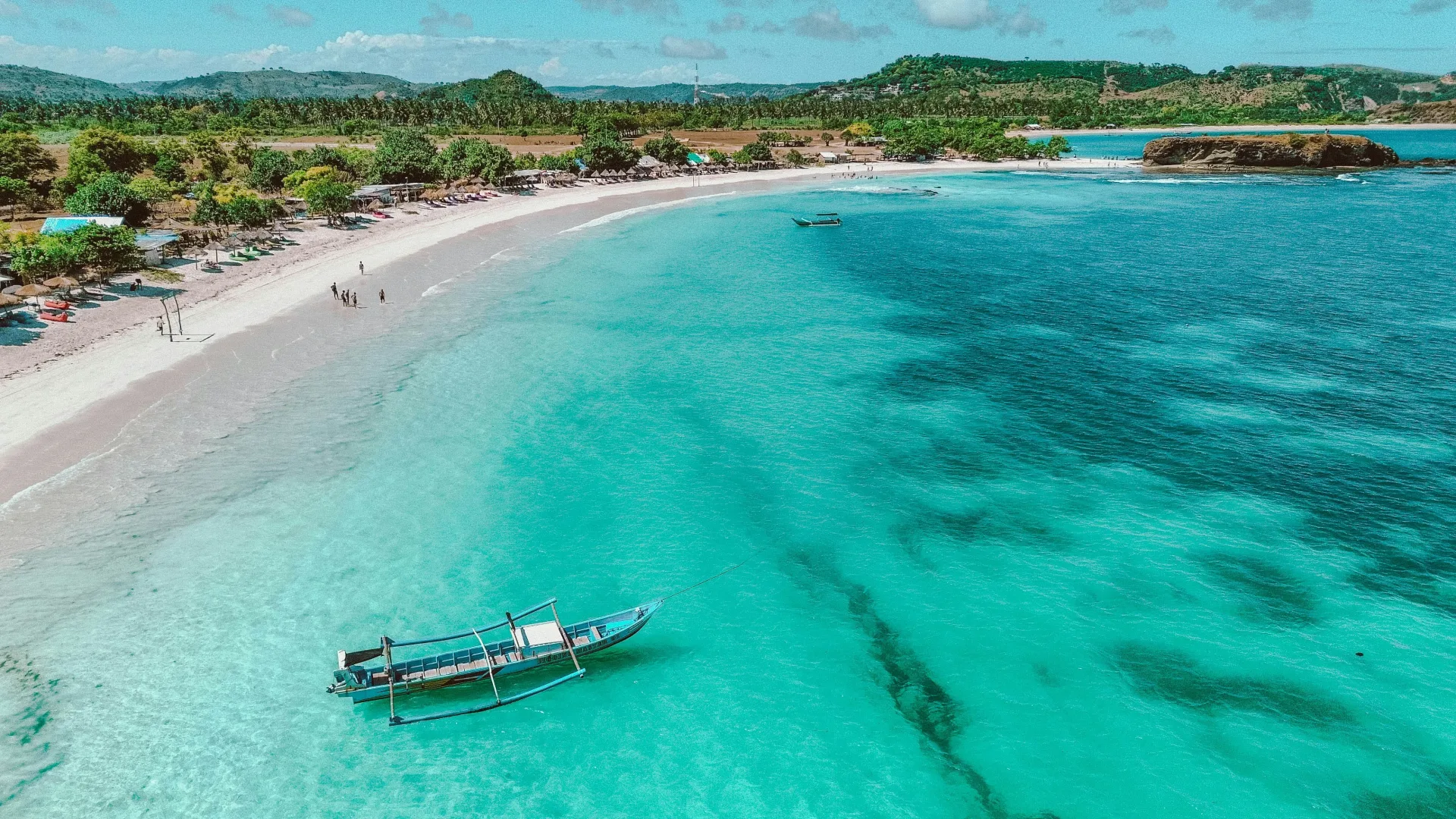Bahía de Selong Belanak en Lombok, con una barca tradicional, ideal para un viaje en familia a Indonesia